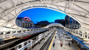 Unique Modern circlar roof over the platforms with the older facade showing throuh it and the neon sign entrance of Union Station