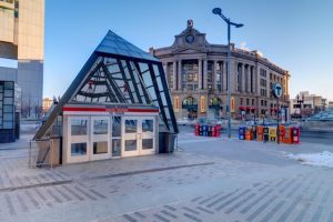 The triangular glass entrance to trains in front of the circular facade entrance to the station