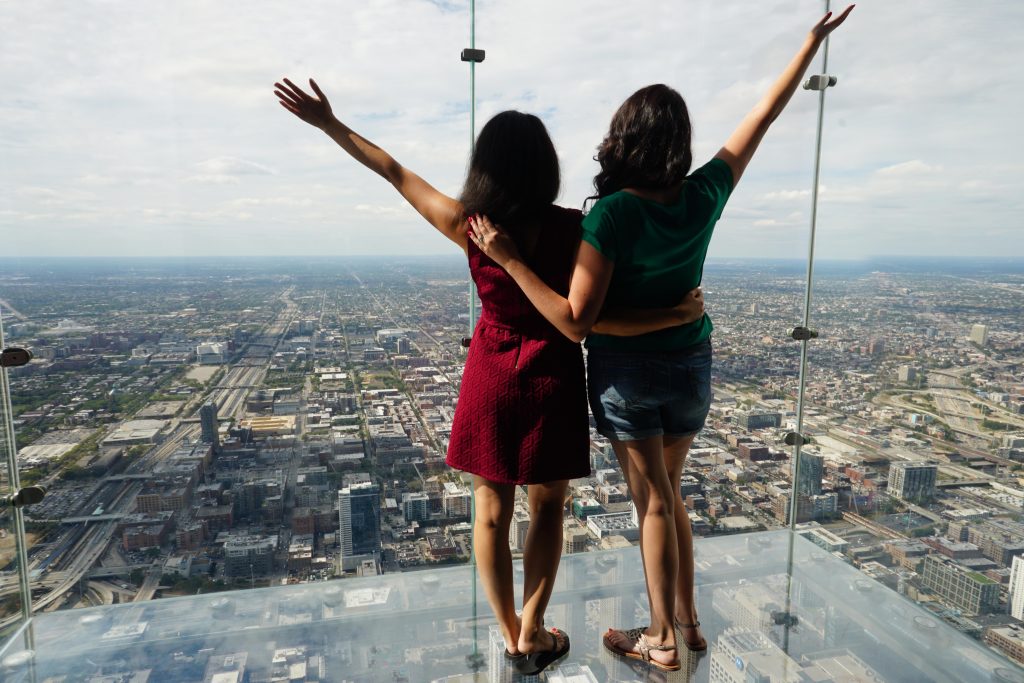 Women on Skydeck The Ledge with arms outstretched