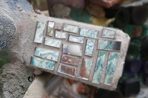 mosaic of mirror pieces through which you can see a white Birdie