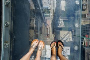 View of our feet looking down through the glass floor of The Ledge