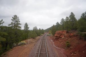 Southwest Chief view from back train window of red rocks and trees