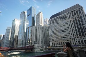 woman taking a photo of the glimmering Chicago skyline