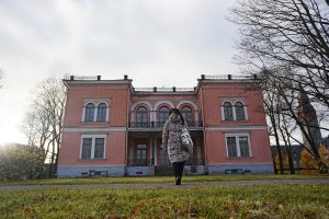 Woman walking towards pink villa