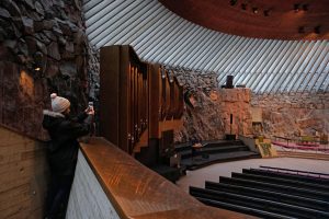 Woman taking a photo on her phone of the rock church