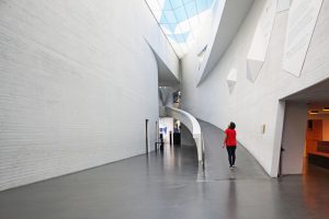 Woman inside large white curved building and curved ramp