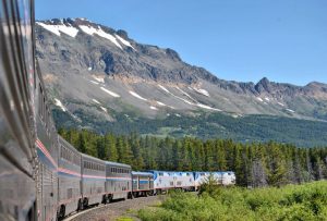 View from the train of the train wrapping around a turn with gorgeous mountains backdrop