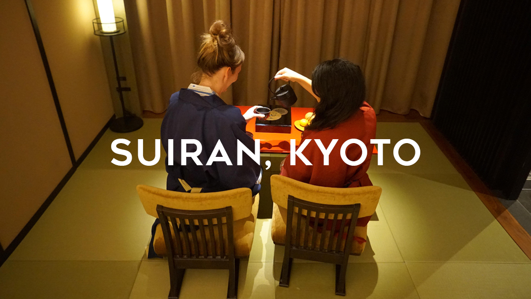 Suiran, Kyoto written over two girls having tea at a red table on the traditional mat and low chairs
