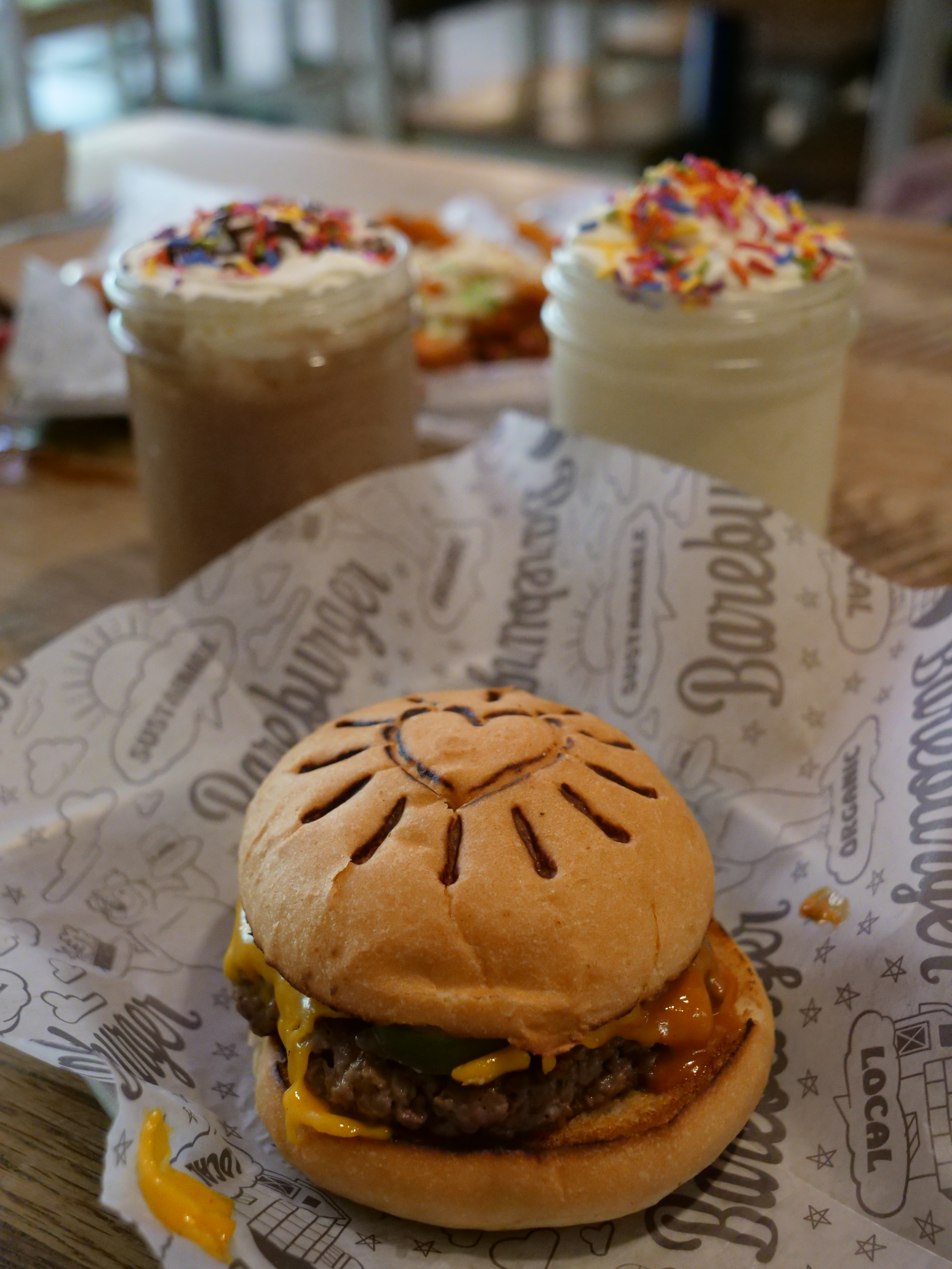 Bareburger Vegan impossible burger with two shakes and sweet potato fries behind it