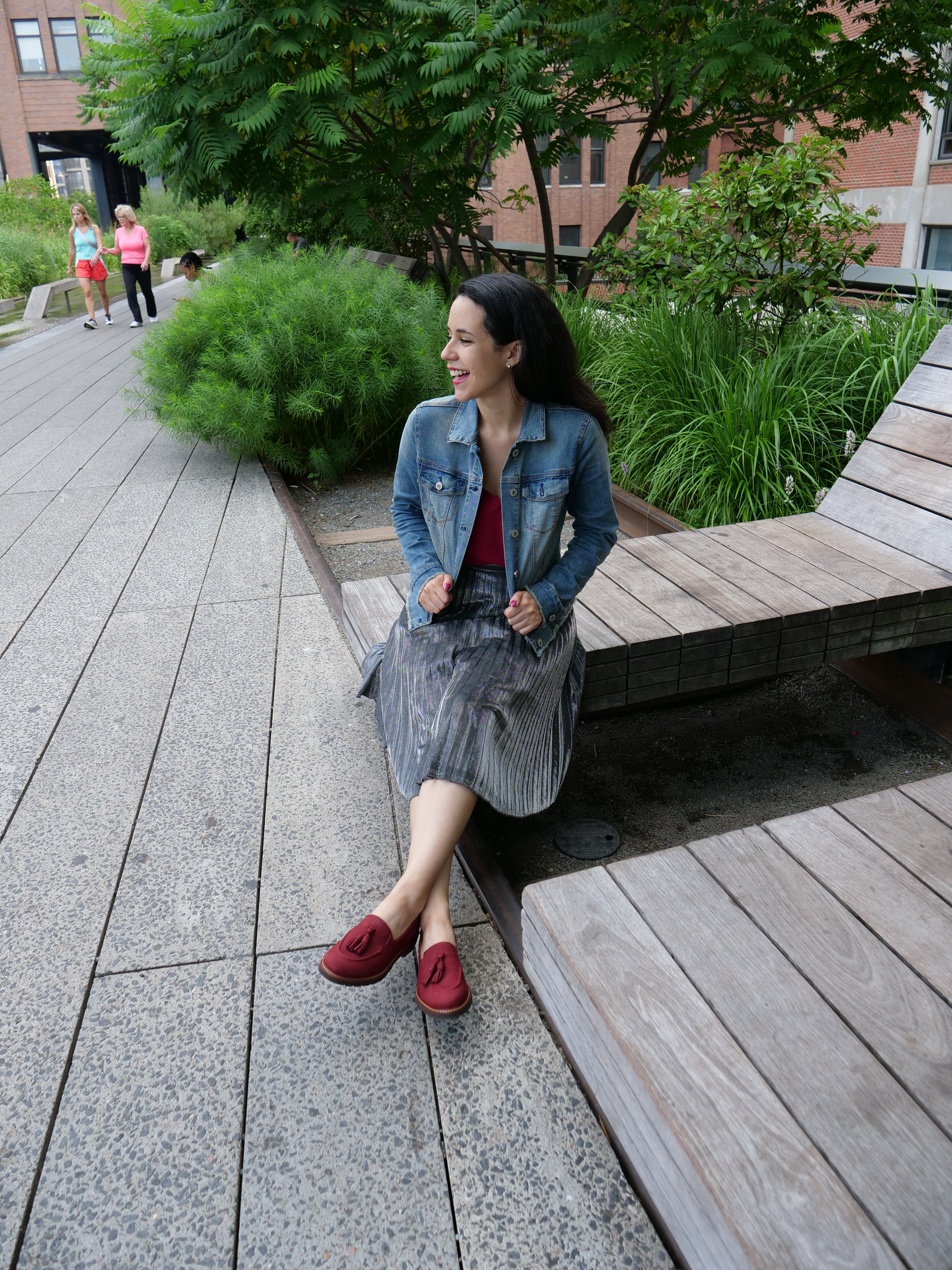 NYC High Line Secret Park benches lounge chairs that move woman in jean jacket sitting