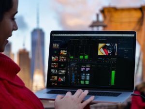 NYC laptop girl in red on computer video editing