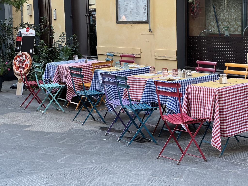 pizza checkered table cloth colorful chairs plaza first solo trip italy