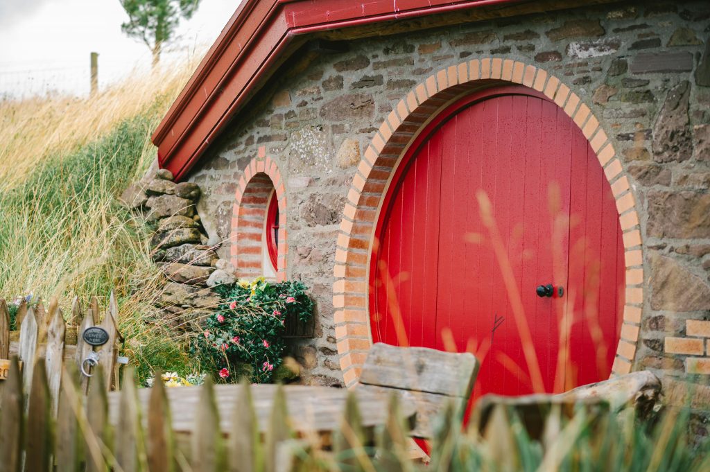 Shire Red and brick and stone round door in the earth hobbit homes