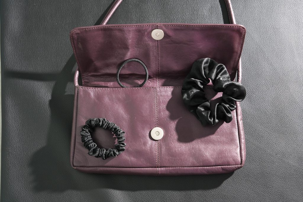 purple leather purse iwth three scrunchies popping out declutter purse before after travel